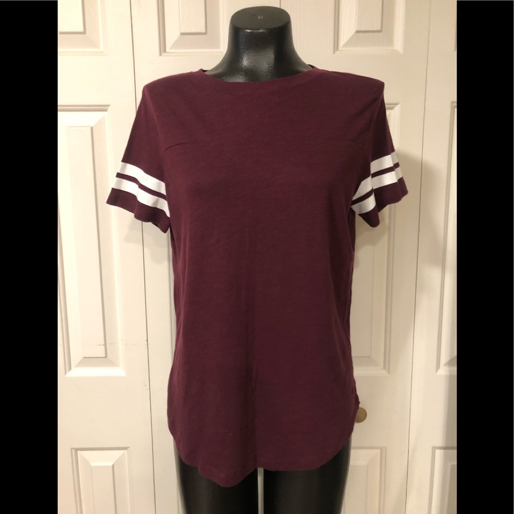 Pink like new maroon short sleeve top with white lines on sleeves .